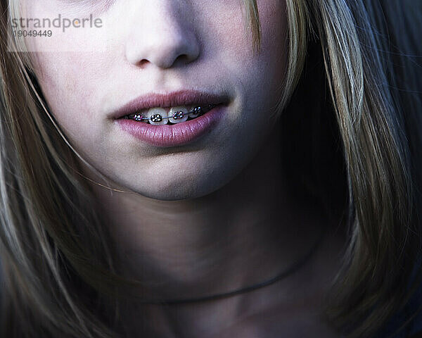 Ausgeschnittenes Porträt eines jungen Mädchens mit Zahnspange.