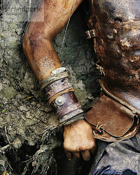Cropped arm and torso in leather armor.