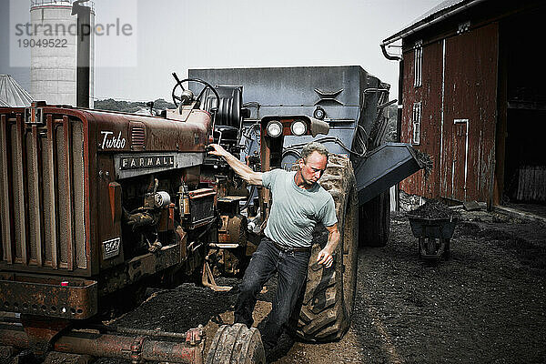 Ein Mann steigt vom Traktor auf der Milchfarm seiner Familie in Keymar  Maryland.