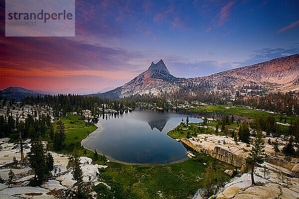 Der Cathedral Peak spiegelte sich während eines Sommersonnenuntergangs im stillen Wasser des Upper Cathedral Lake im Hinterland des Yosemite-Nationalparks.