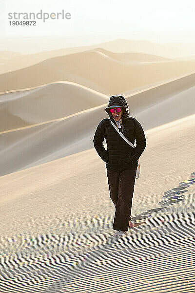 Lächelnde Frau  die durch die Wüste im Great Sand Dune National Park wandert