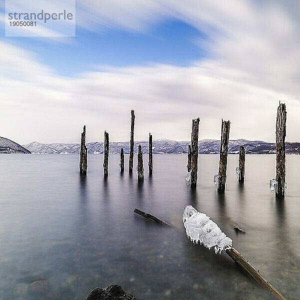 Langzeitbelichtung von Holzstäben im Wasser am Toya-See  Hokkaido  Japan