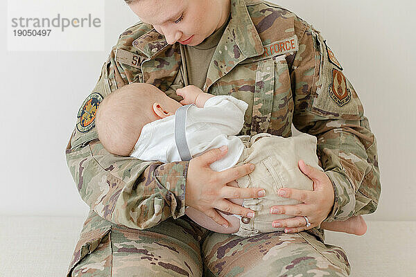 Ein aktiver Luftwaffenflieger stillt in Uniform sein Baby