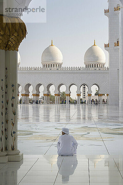 Alter Mann in weißer traditioneller Kleidung mit Blick auf die Scheich-Zayid-Moschee