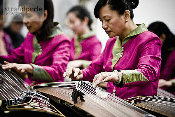 Frauen spielen während des chinesischen Neujahrs 2009 traditionelle chinesische Gu-Zheng-Musik.