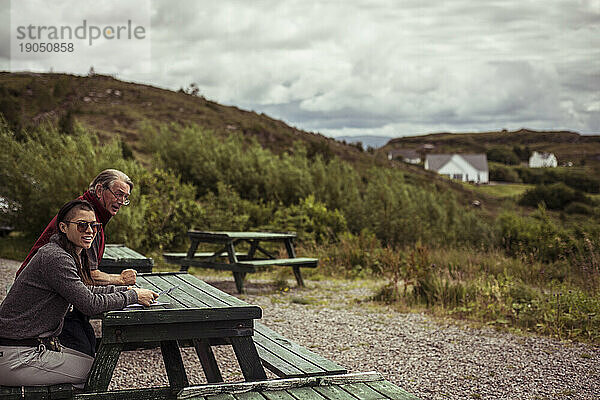 Zwei Personen blicken auf die schottischen Highlands