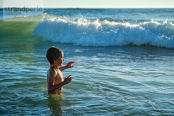 Junge hat Spaß genießt springt taucht in Ozean Meer Wellen des Atlantischen Ozeans. Strand Fonta da Telha  Costa da Caparica  Portugal  Europa