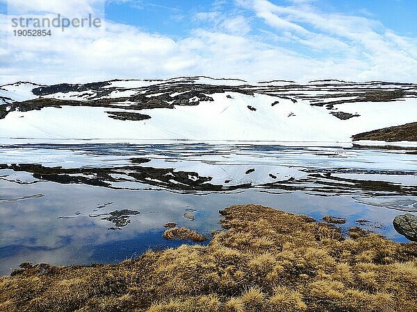 Schneebedeckter Berg spiegelt sich in einem See  Aurlandsfjellet  Norwegen  Europa