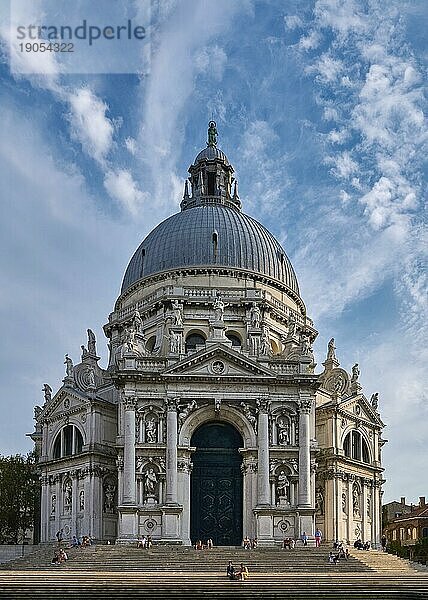 Schöner Blick auf die ikonische Basilika di Santa Maria della Salute oder St. Mary of Health am Ufer des Canal Grande  Venedig  Italien. Berühmtes Wahrzeichen am Canal Grande und Vaporetto Route von St. Mark Platz. Blauer Himmel  große Wolken. Vertikaler Aufriss