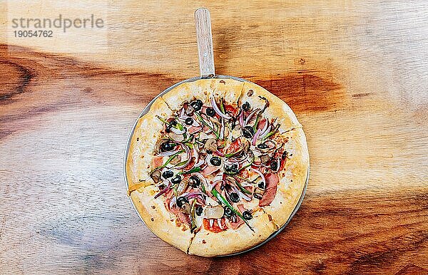 Draufsicht auf Super Pizza mit Oliven auf dem Holztisch. Hohe Winkel Ansicht der höchsten Pizza mit Oliven auf hölzernen Hintergrund