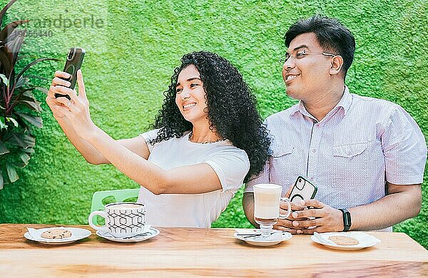 Zwei glückliche Freunde  die einen Kaffee trinken und ein Selfie machen. Ein paar Freunde sitzen und genießen einen Kaffee und machen ein Selfie
