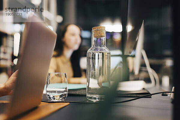 Wasserflasche und Glas auf dem Schreibtisch im Büro