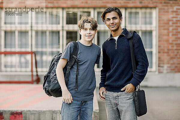 Porträt von lächelnden männlichen Teenagern  die auf einem Highschool-Campus zusammenstehen