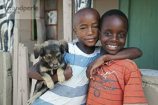 Zwei lächelnde  glückliche afrikanische Kinder in einem Township bei Swakopmund  Namibia  Südafrika  Afrika