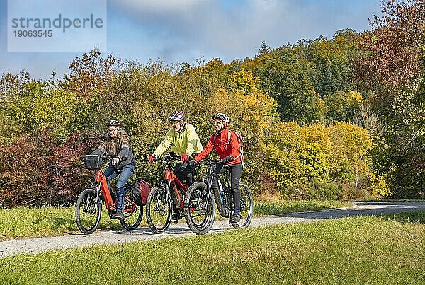 Drei glückliche  aktive Senioren fahren mit ihren Mountainbikes in der herbstlichen Atmosphäre der Herbstwälder rund um die Stadt Stuttgart  Baden-Württemberg  Deutschland  Europa