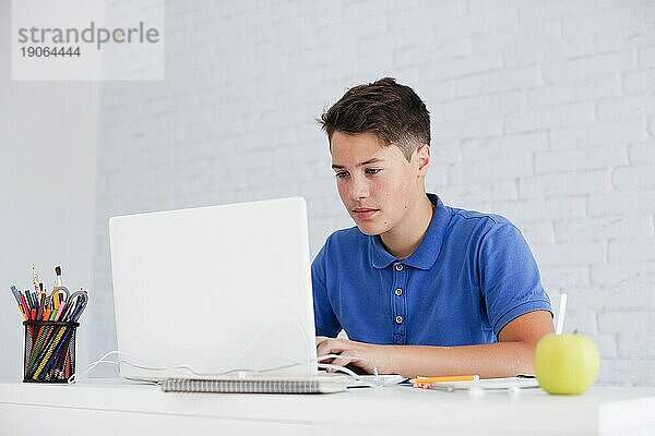 Seriöser Mann studiert mit Laptop am Schreibtisch