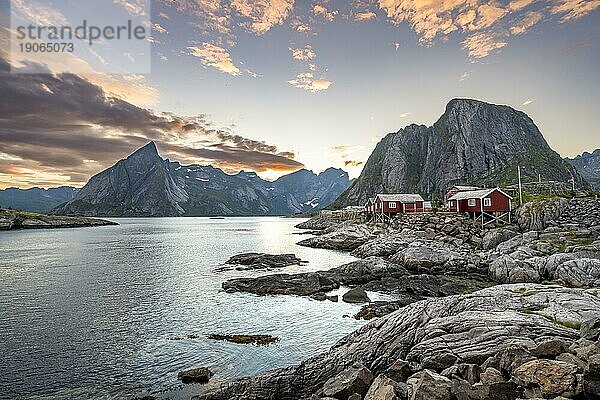 Rote Holzhütten  traditionelle Rorbuer Hütten  Fischerdorf Hamnøy bei Sonnenuntergang  felsige steile Berggipfel und Fjordlandschaft  Lofoten  Nordland  Norwegen  Europa