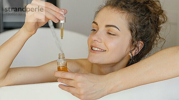 Frau entspannt sich in der Badewanne mit Serum