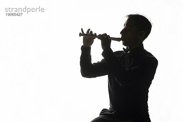 Silhouette Mann spielt Flöte