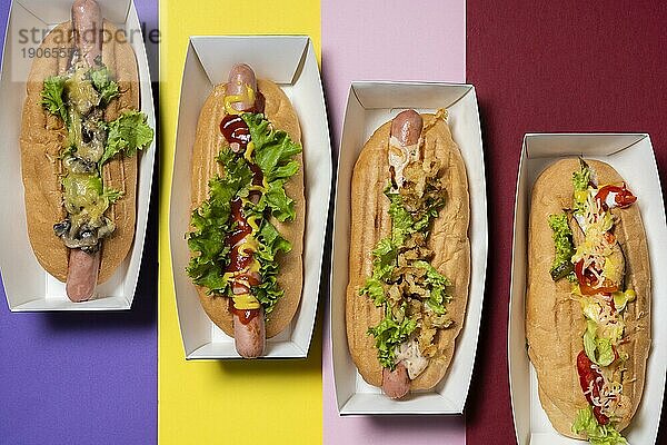 Draufsicht auf vier unterschiedlich gefüllte Hot Dogs