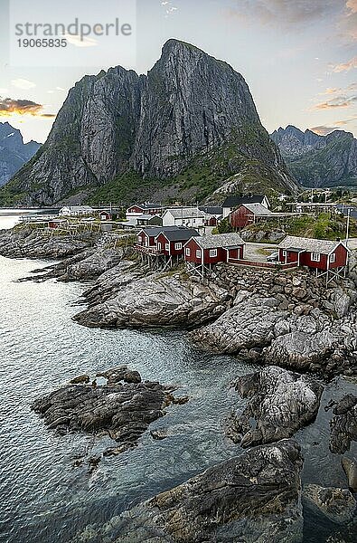 Rote Holzhütten  traditionelle Rorbuer Hütten  Fischerdorf Hamnøy bei Sonnenuntergang  felsige steile Berggipfel und Fjordlandschaft  Lofoten  Nordland  Norwegen  Europa