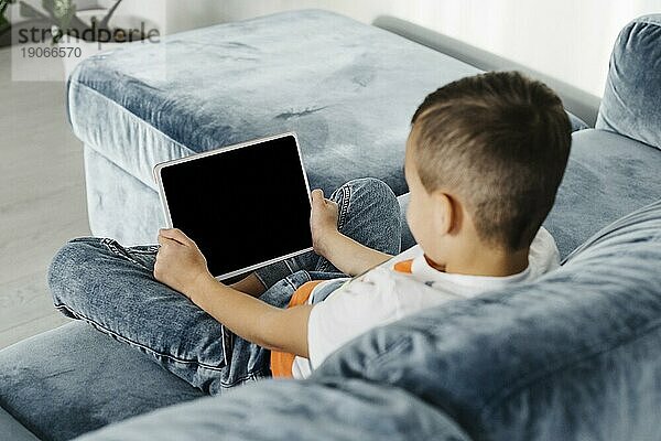 Schulterblick Junge mit digitalem Tablet