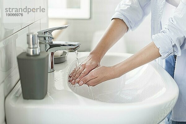 Seitenansicht Frau wäscht sich mit Wasser die Hände