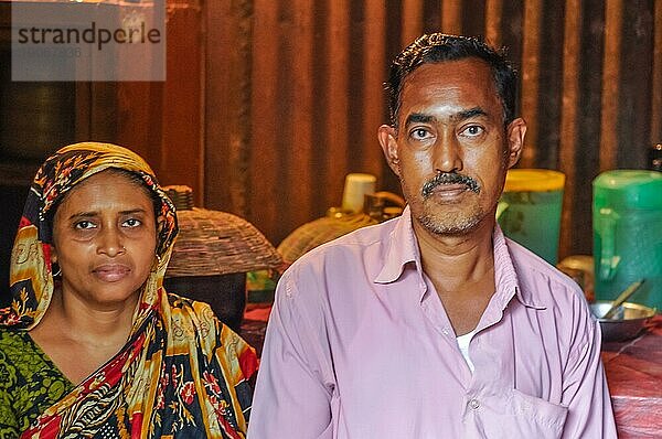 Morolgang  Bangladesch  ca. Juli 2012: Schwarzhaariger Mann mit Schnurrbart in rosa Hemd mit seiner Frau mit buntem Kopftuch in Morolgang  Bangladesch. Dokumentarischer Leitartikel  Asien