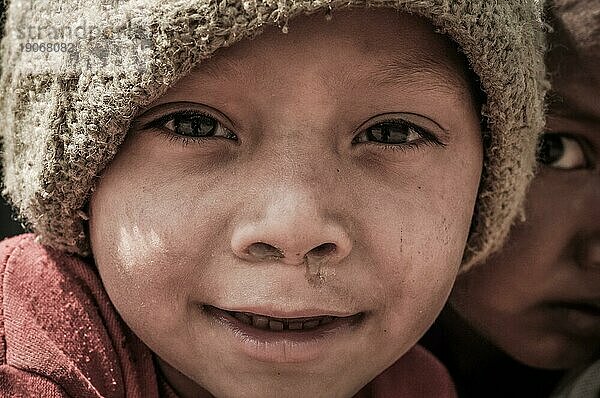 Beni  Nepal  ca. Mai 2012: Junge mit braunen Augen und brauner Mütze auf dem Kopf lächelt freundlich in die Fotokamera in den Straßen von Beni  Nepal. Dokumentarischer Leitartikel  Asien