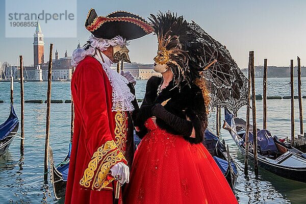 Karnevalsmasken an der Wasserfront mit der Insel San Giorgio zur Zeit vom Karneval  Venedig  Venetien  Norditalien  Italien. UNESCO-Weltkulturerbe