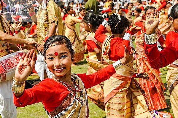 Guwahati  Assam  etwa im April 2012: Ein tanzendes Mädchen in einem rot gelben Sari mit einem roten Punkt auf der Stirn lächelt während eines Auftritts beim traditionellen Bihu Fest in Guwahati  Assam. Dokumentarischer Leitartikel