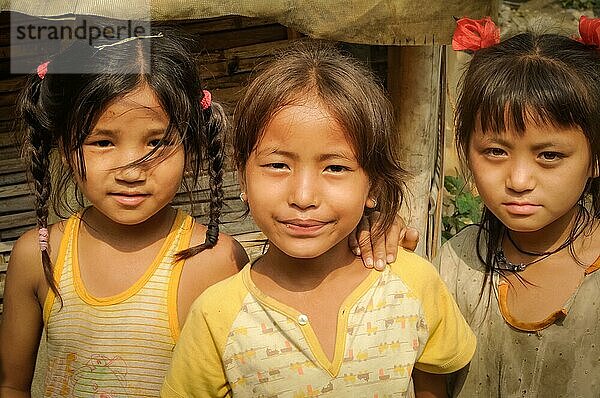 Damak  Nepal  ca. Mai 2012: Drei junge Mädchen in gelben T Shirts stehen nebeneinander und schauen in die Fotokamera im nepalesischen Flüchtlingslager in Damak  Nepal. Dokumentarischer Leitartikel  Asien