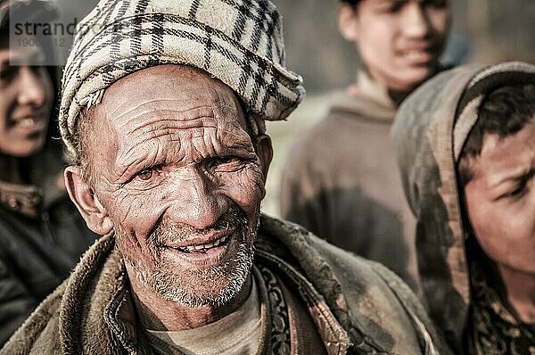 Dolpo  Nepal  ca. Mai 2012: Alter Eingeborener mit kleinem Bart trägt braune Kopfbedeckung und Jacke und schaut stirnrunzelnd in die Kamera in Dolpo  Nepal. Dokumentarischer Leitartikel  Asien