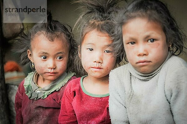Dolpo  Nepal  etwa im Mai 2012: Foto von drei jungen braunhaarigen und braunäugigen Mädchen in Dolpo  Nepal. Zwei Mädchen tragen rosa Hemden und eines trägt ein weißes Sweatshirt. Dokumentarischer Leitartikel  Asien