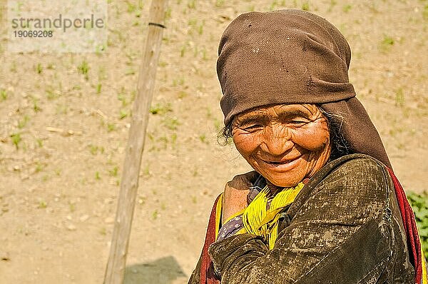 Dolpo  Nepal  etwa im Mai 2012: Alte einheimische Frau mit faltigem Gesicht und braunem Kopftuch blickt herab und lächelt freundlich in Dolpo  Nepal. Dokumentarischer Leitartikel  Asien
