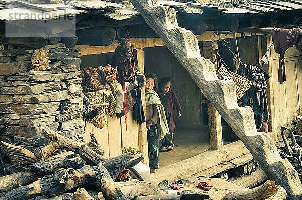 Dolpo  Nepal  etwa im Mai 2012: Zwei kleine Kinder posieren in ihrem einfachen Holzhaus mit Steinen an der Seite in Dolpo  Nepal. Dokumentarischer Leitartikel  Asien