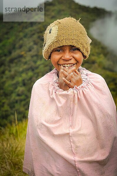 Dorf Sara  Mt. Michael  Papua Neuguinea  Juli 2015: Junges Eingeborenenmädchen mit brauner Strickmütze trägt rosa Tuch und lächelt freundlich in die Fotokamera im Dorf Sara  Mt. Michael in Papua Neuguinea. Dokumentarischer Leitartikel