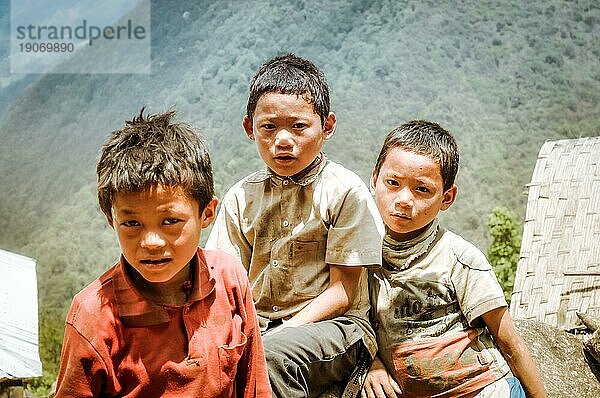 Kanchenjunga Trek  Nepal  etwa im Mai 2012: Drei junge braunhaarige Jungen stehen nebeneinander und schauen traurig in die Fotokamera in Kanchenjunga Trek  Nepal. Dokumentarischer Leitartikel  Asien