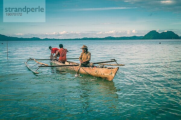 Sulawesi  Indonesien  Mai 2015: Drei einheimische Männer segeln in einem Fischerboot auf dem Meer in Malange auf den Togean Inseln in Sulawesi  Indonesien. Dokumentarischer Leitartikel  Asien