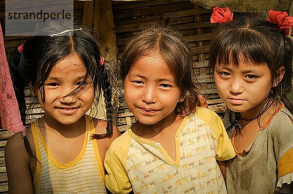 Damak  Nepal  ca. Mai 2012: Foto von drei jungen Mädchen in gelben T Shirts  die nebeneinander stehen  im nepalesischen Flüchtlingslager in Damak  Nepal. Dokumentarischer Leitartikel  Asien