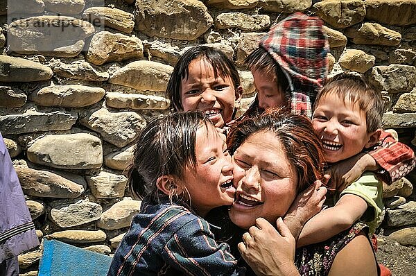 Dolpo  Nepal  etwa im Juni 2012: Kleine Kinder umarmen ihre Mutter und lächeln freudig in die Kamera in Dolpo  Nepal. Dokumentarischer Leitartikel  Asien