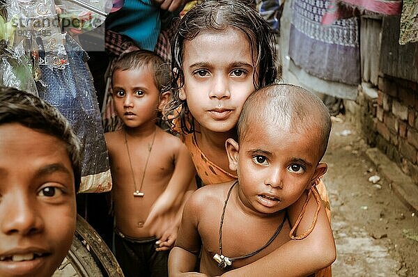 Khulna  Bangladesch  ca. Juli 2012: Junge einheimische Kinder mit braunen Haaren und braunen Augen schauen neugierig in die Kamera in einem Slum in Khula  Bangladesch. Dokumentarischer Leitartikel  Asien