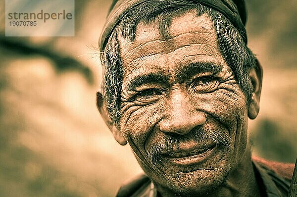 Dolpo  Nepal  ca. Mai 2012: Foto eines alten  faltigen Mannes mit grauem Haar und Schnurrbart  der freundlich in die Kamera lächelt  in Dolpo  Nepal. Dokumentarischer Leitartikel  Asien
