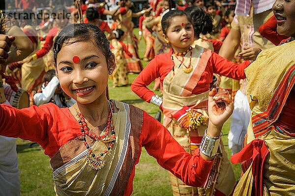 Guwahati  Assam  ca. April 2012: Junges einheimisches Mädchen in rotem und gelbem Sari lächelt und tanzt während einer Aufführung beim traditionellen Bihu Fest in Guwahati  Assam. Dokumentarischer Leitartikel