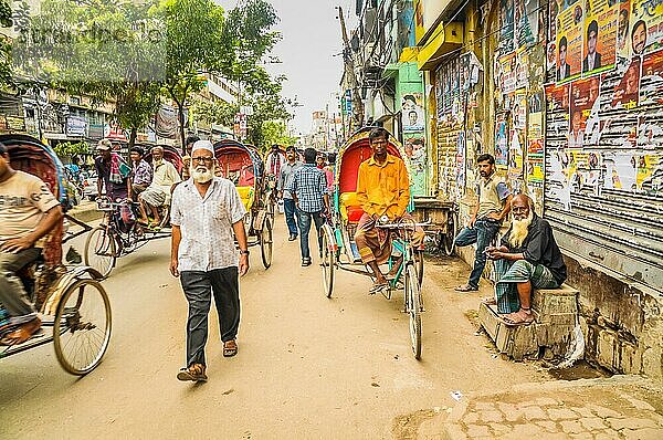 Dhaka  Bangladesch  etwa im Juli 2012: Fußgänger und Menschen auf Rikschas eilen durch eine belebte Straße und schauen in die Kamera in Dhaka  Bangladesch. Dokumentarischer Leitartikel  Asien