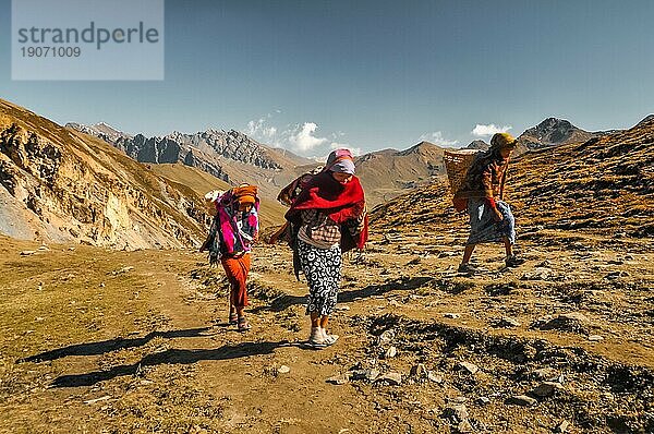 Dolpo  Nepal  ca. Mai 2012: Einheimische Frauen mit Körben auf dem Rücken wandern in der Bergregion von Dolpo  einen Hügel hinauf. Dokumentarischer Leitartikel  Asien