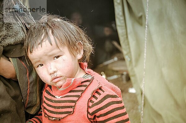 Dolpo  Nepal  ca. Juni 2012: Ein kleines braunhaariges Mädchen in einem schwarz rot gestreiften Hemd schaut traurig in die Kamera in Dolpo  Nepal. Dokumentarischer Leitartikel  Asien
