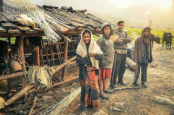 Dolpo  Nepal  etwa im Mai 2012: Junge einheimische Mädchen und Jungen posieren vor der Kamera in der Nähe eines hölzernen Kuhstalls in Dolpo  Nepal. Dokumentarischer Leitartikel  Asien