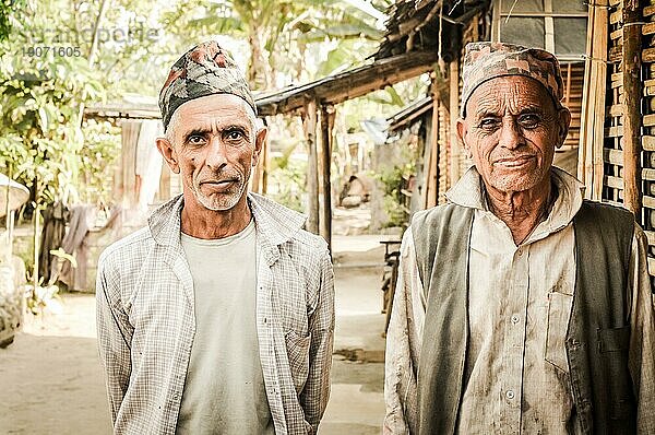 Damak  Nepal  etwa im April 2012: Foto von zwei älteren Männern mit Mützen auf dem Kopf und weißen Hemden  die in die Kamera schauen  im nepalesischen Flüchtlingslager in Damak  Nepal. Dokumentarischer Leitartikel  Asien