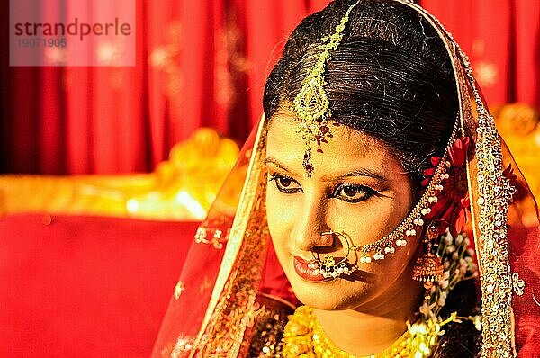 Dhaka  Bangladesch  ca. Juli 2012: Foto der jungen schwarzhaarigen Braut mit Piercing und mit goldglitzerndem Schleier auf dem Kopf  die während ihrer Hochzeit in Dhaka  posiert. Dokumentarischer Leitartikel  Asien